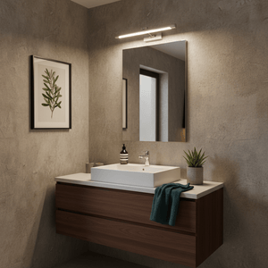Stainless steel LED bathroom mirror light mounted above a modern sink with a plant and decorative items.