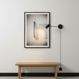Modern wall lamp with a framed artwork on a white wall, featuring a wooden bench below.