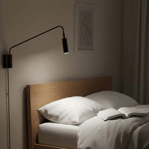 Corded LED reading light mounted above a wooden headboard, illuminating an open book on a bed.