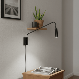 Corded LED reading light mounted above a wooden bedside table with a magazine, plant, and cup.