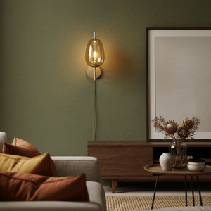 Dazzle Gold & Amber indoor wall light mounted on a green wall, illuminating a cozy living space with decorative pillows and