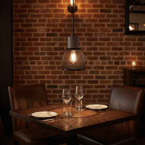 Midnight Dome Mesh & Stone Pendant Light hanging over a dining table with glassware and plates, against a brick wall.