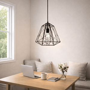 Black metal pendant light hanging above a wooden table with a laptop and flowers.