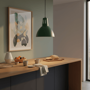 Green steel pendant light hanging above a wooden countertop with fruit, cups, and bread.