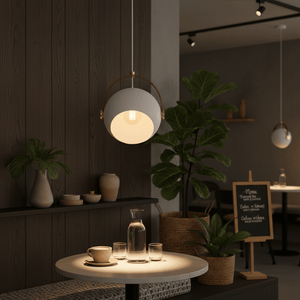 White leather strap pendant light hanging above a table with drinks and plants in a modern setting.