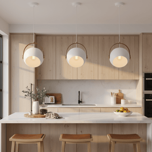 Three white leather strap pendant lights hanging above a modern kitchen island with wooden cabinets.