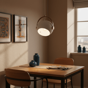 White leather strap pendant light hanging above a wooden dining table, with decorative vases and artwork in the background.