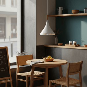 Scandinavian-style LED pendant light hanging above a wooden dining table with fruit bowl and chairs.