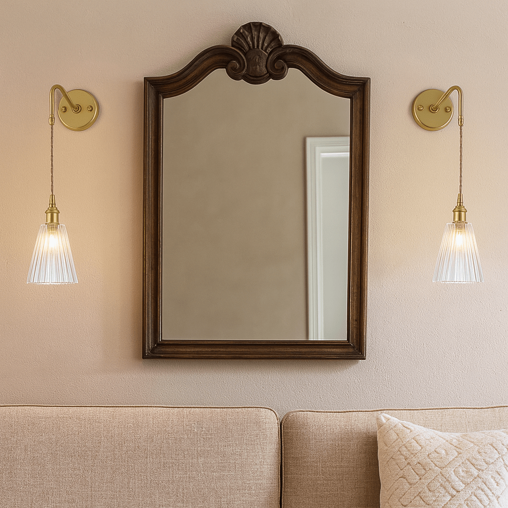 Vintage glass wall light mounted beside an ornate mirror, illuminating a cozy living space.