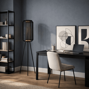 Sleek black metal floor lamp beside a modern desk in a stylish indoor workspace.