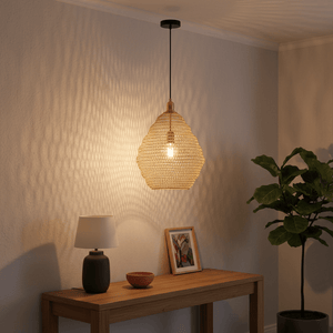 Gold mesh pendant light casting textured patterns on the wall, above a wooden console table with decor.