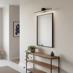 Slim black LED picture light mounted above a mirror, illuminating the space with cool white light.