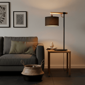 Shawela Black Table Lamp on a side table next to a gray sofa, with decorative items and a woven basket.