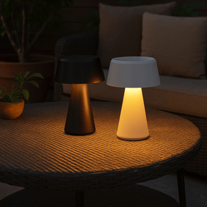 Two outdoor lamps on a table with a dark background