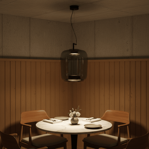 Magnum Maxima Green LED Pendant hanging over a round dining table with wooden chairs and a floral centerpiece.
