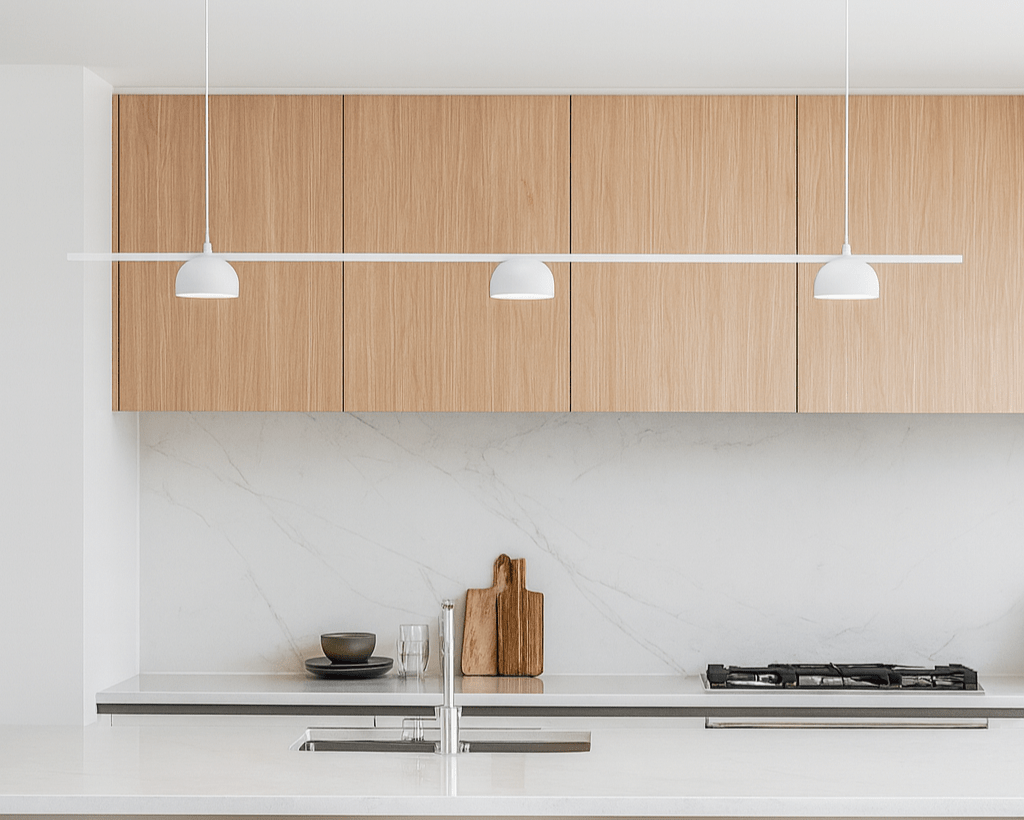 Modern kitchen with wooden cabinets, white countertops, and pendant lights.