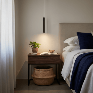 Slim LED pendant light hanging above a bedside table with a plant and an open book.