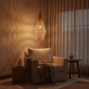 Woven rattan pendant light casting warm shadows above a cozy armchair with a blanket.