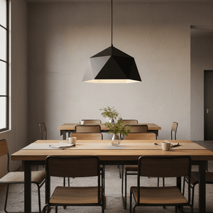 Black metal pendant light hanging over a wooden dining table with chairs, featuring a minimalist design.