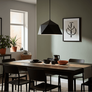 Black metal pendant light hanging over a dining table set with plates and bowls, surrounded by chairs.