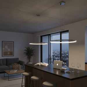 Two chrome LED ring pendant lights hanging over a modern kitchen island, creating a warm ambiance.
