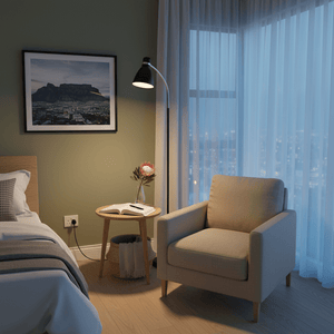 Black metal flexi head floor lamp beside a cozy armchair and side table in a softly lit room.