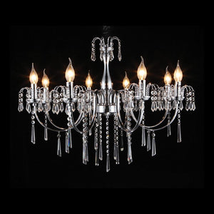 Eight-light chrome and crystal chandelier with illuminated bulbs against black background