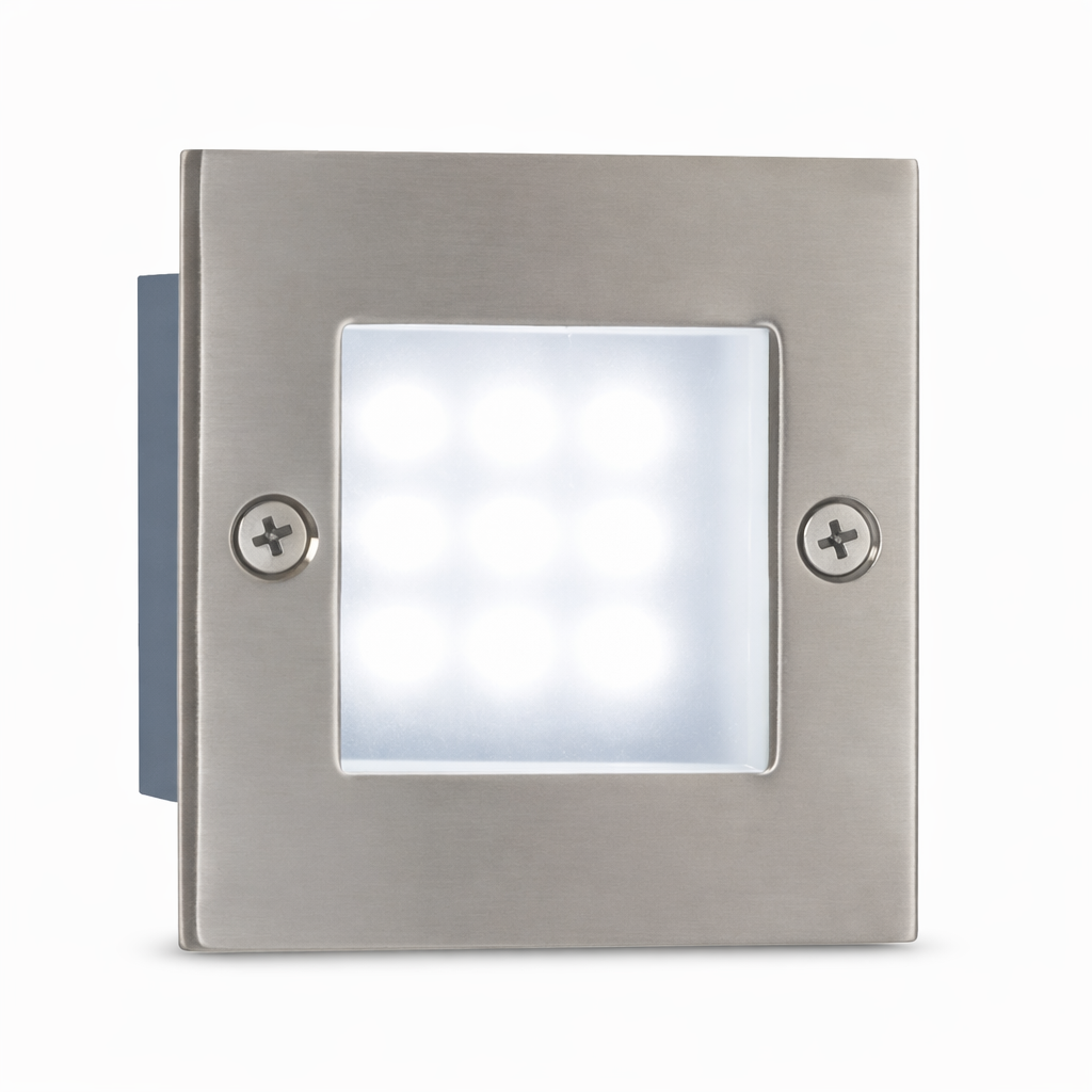 Square stainless steel LED foot light on a bathroom wall, soft white glow across light grey tiles, matching stainless taps and accessories, realistic shadows, no text or logos.