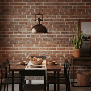 Stylish black and gold pendant light hanging over a dining table set with plates and a basket of bread.