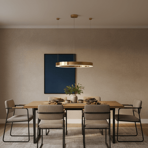 Halo Gold LED Pendant light hanging above a modern dining table set with dishes and a plant.