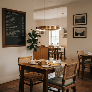 Halo Gold LED Pendant light hanging above a dining table set with cups and a basket in a cozy restaurant.