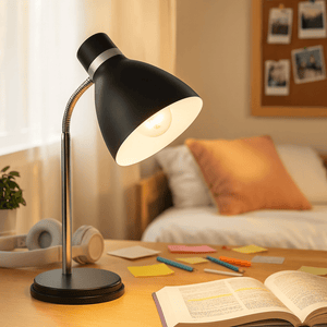 Black metal desk lamp with flexible gooseneck illuminating a study area with books and stationery.
