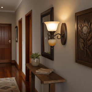 Indoor wall light with faded brown glass mounted beside a wooden console table in a hallway.