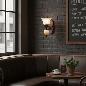 Indoor scene featuring a metal wall bracket light with faded brown glass, illuminating a cozy seating area.