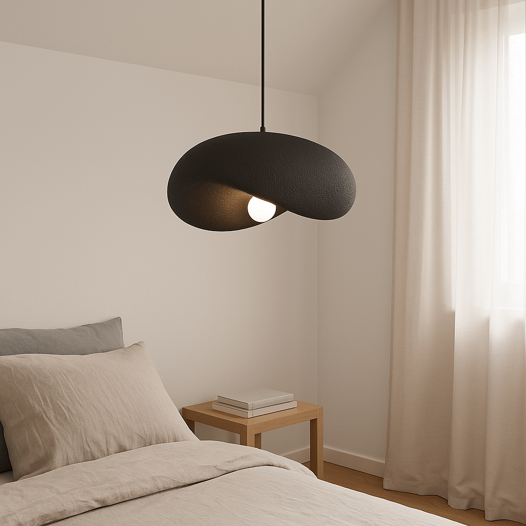 Obsidian Drift 500 Pendant Light hanging above a bed with neutral bedding and a wooden side table.