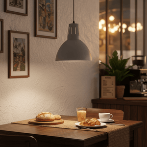 Stylish steel pendant light hanging above a dining table with pastries and drinks.