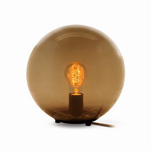 Modern table lamp with a round opal shade and visible bulb, designed for soft ambient lighting.
