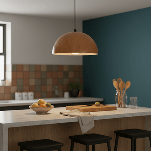 Dome wood grain pendant light hanging above a kitchen island with a bowl of fruit and wooden utensils.