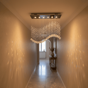 Waverley Chrome Chandelier illuminating a stylish hallway with crystal detailing and warm light.