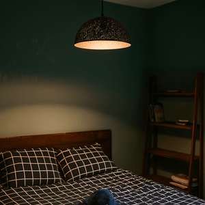 Bedroom with a bed, lamp, and bookshelf in a dimly lit room.