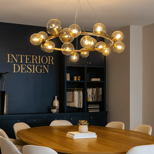 Modern dining room with a chandelier, round table, and white chairs.