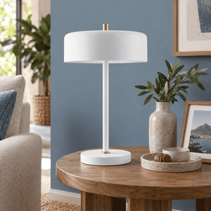 Diaz white table lamp on a side table against a dusty blue wall
