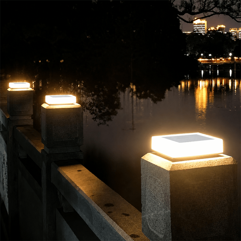 Solar CCT Pillar Top Light illuminating a stone pillar along a waterfront at night.