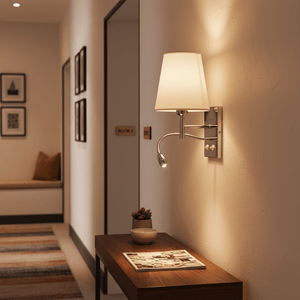 Polished chrome wall fitting with white shade illuminating a hallway, featuring a gooseneck light and decorative elements.