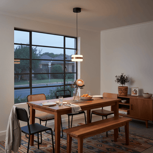 Modern pendant light with a black fixture and white shade on a white background