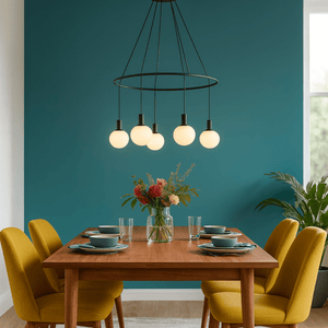 Dining room with a wooden table, yellow chairs, and a modern chandelier against a teal wall.