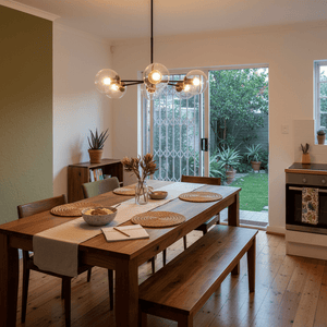 5-light pendant light above a wooden dining table set with plates and a vase, showcasing a modern interior.