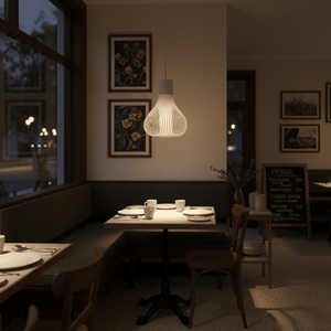 Scandi white pendant light hanging above a dining table in a cozy restaurant setting.