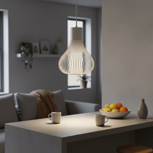 Scandi white pendant light hanging above a minimalist dining table with fruit bowl and coffee mugs.