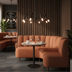 Lander 8 Light Pendant illuminating a cozy dining area with orange seating and a round table.